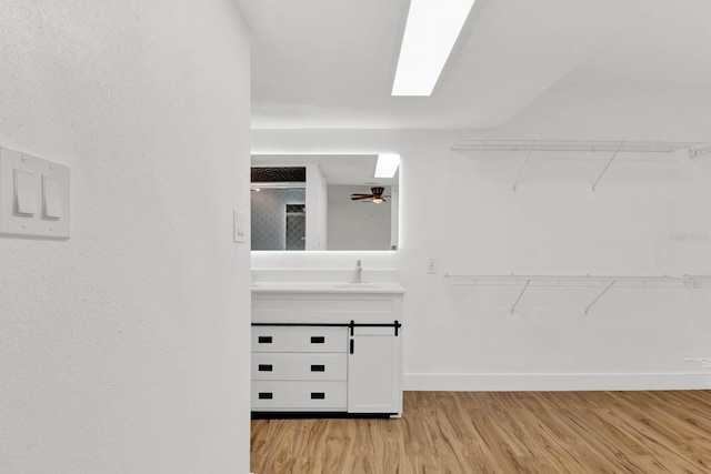 walk in closet featuring light hardwood / wood-style flooring and ceiling fan