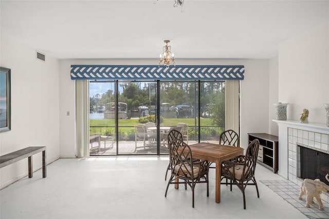 dining room featuring a fireplace and concrete floors