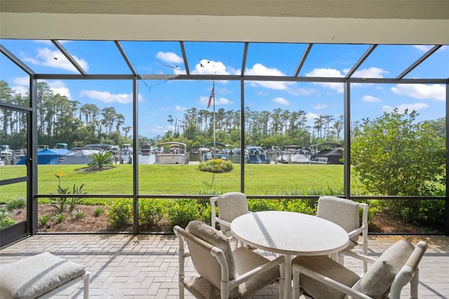 sunroom featuring a water view