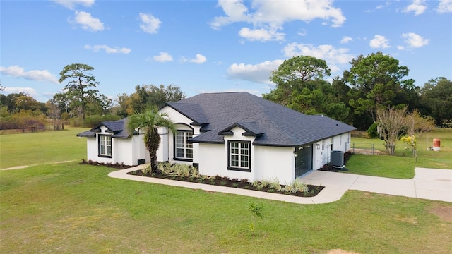 view of front of property featuring a garage, a front lawn, and central air condition unit