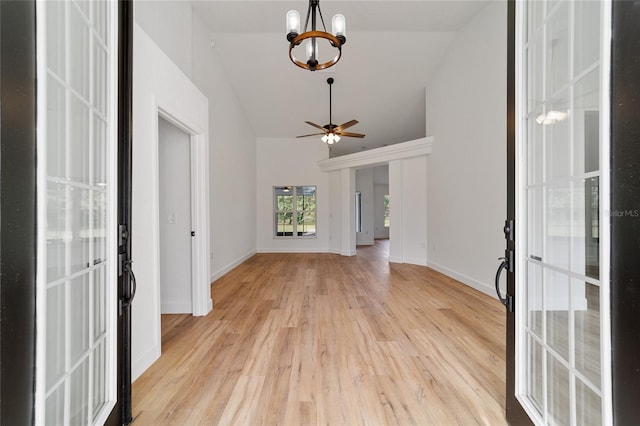 entrance foyer featuring french doors, ceiling fan with notable chandelier, light hardwood / wood-style floors, and lofted ceiling