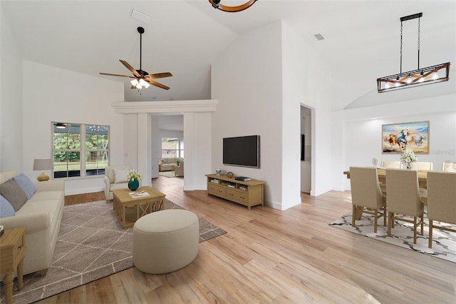 living room featuring high vaulted ceiling, light hardwood / wood-style flooring, and ceiling fan