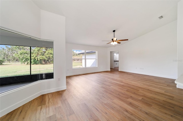 empty room with ceiling fan, vaulted ceiling, and hardwood / wood-style flooring