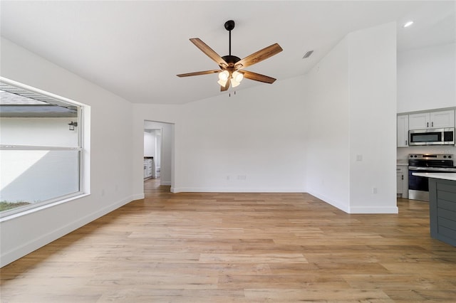 unfurnished living room featuring ceiling fan, light hardwood / wood-style floors, and lofted ceiling