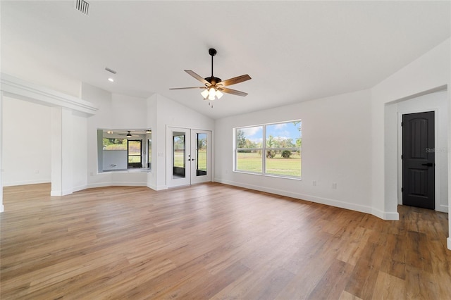 unfurnished living room featuring ceiling fan, a healthy amount of sunlight, vaulted ceiling, and light wood-type flooring