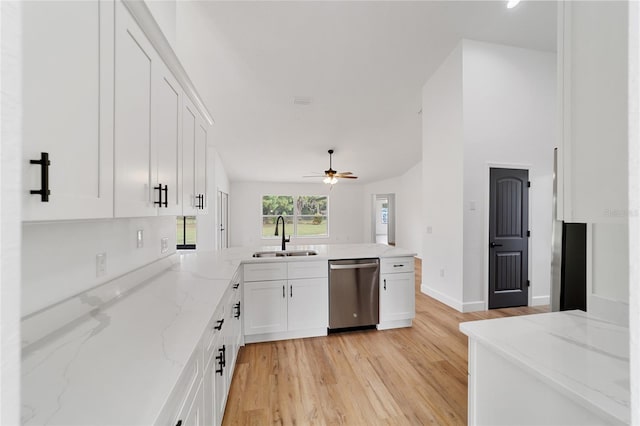 kitchen with light stone counters, sink, light hardwood / wood-style flooring, dishwasher, and white cabinetry