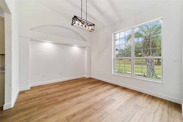 unfurnished dining area with an inviting chandelier and light hardwood / wood-style flooring