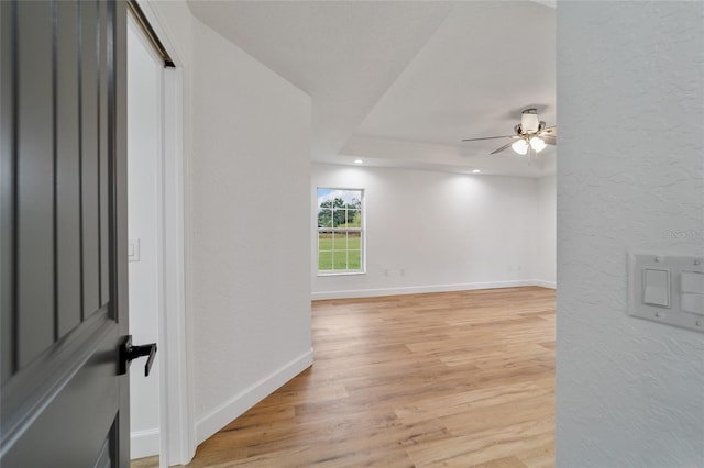 empty room with ceiling fan and light hardwood / wood-style flooring