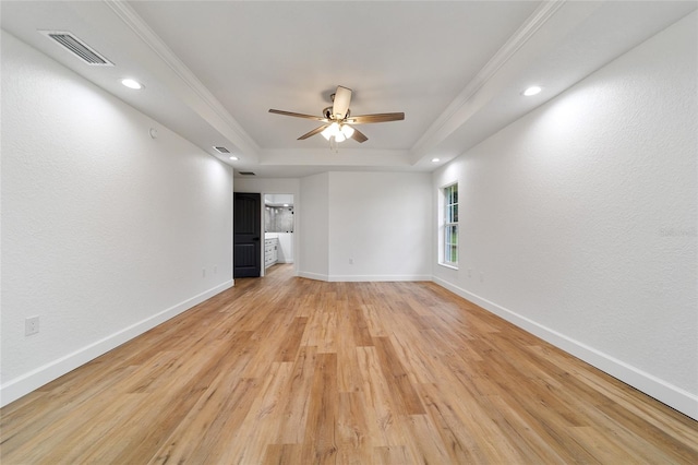 interior space featuring a raised ceiling, ceiling fan, ornamental molding, and light wood-type flooring