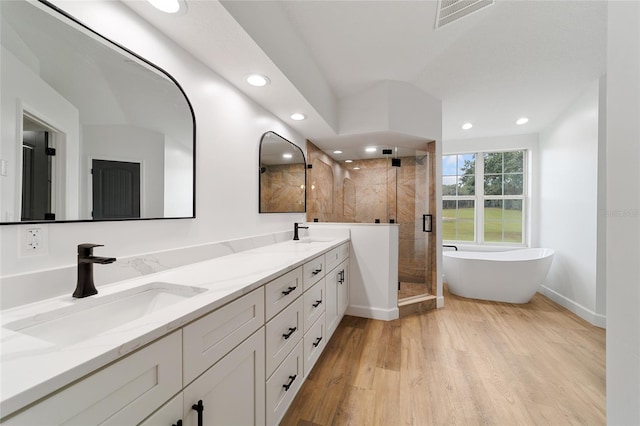 bathroom featuring hardwood / wood-style floors, vanity, separate shower and tub, and vaulted ceiling