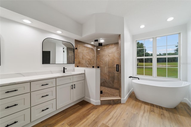 bathroom featuring separate shower and tub, hardwood / wood-style floors, and vanity