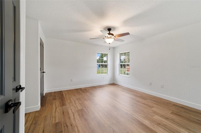 spare room featuring ceiling fan, light hardwood / wood-style floors, and a textured ceiling