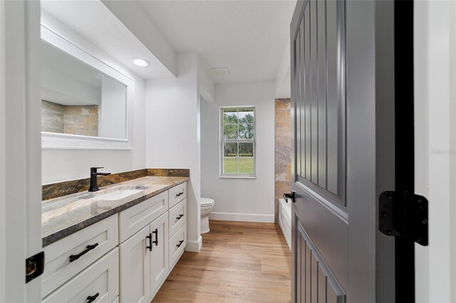 full bathroom with wood-type flooring, vanity, toilet, and  shower combination