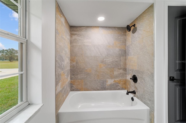 bathroom featuring plenty of natural light and tiled shower / bath combo