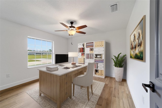 office area with ceiling fan, light hardwood / wood-style floors, and a textured ceiling