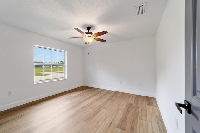 unfurnished room with ceiling fan, light hardwood / wood-style floors, and a textured ceiling