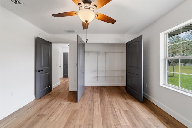 unfurnished bedroom featuring multiple windows, light hardwood / wood-style floors, and ceiling fan