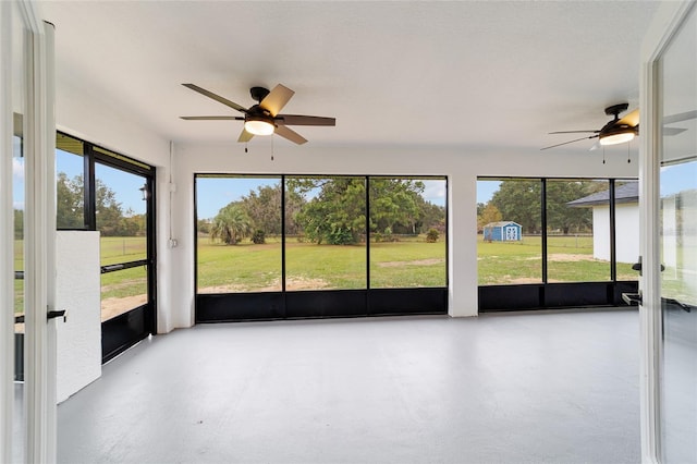 unfurnished sunroom with ceiling fan