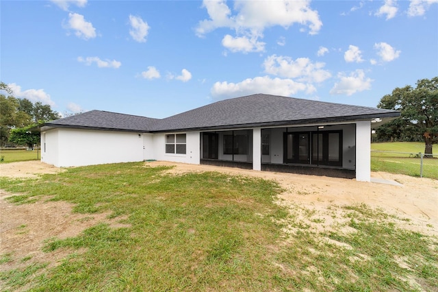 rear view of property featuring a yard