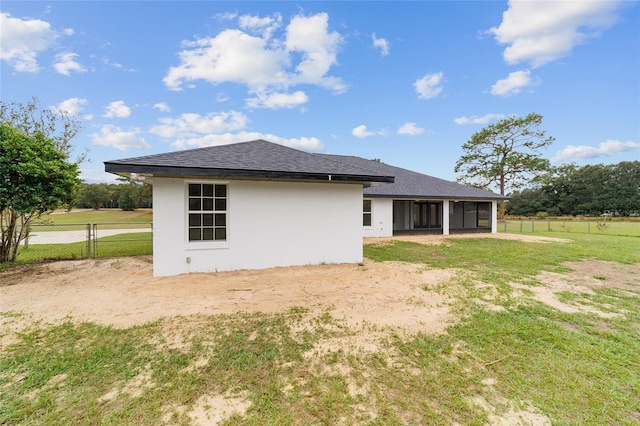 back of property with a sunroom and a yard