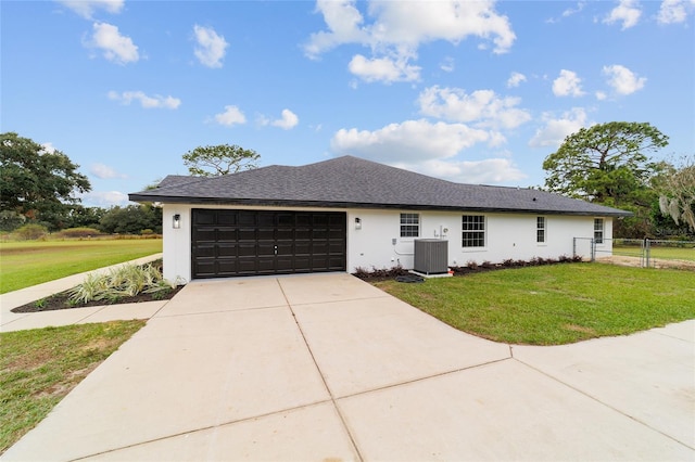 ranch-style home featuring cooling unit, a front lawn, and a garage