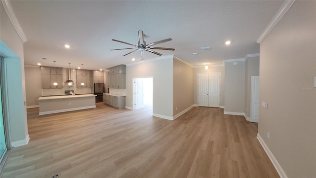 unfurnished living room with crown molding, ceiling fan, and light hardwood / wood-style floors