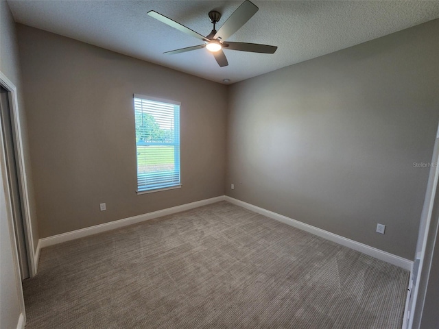 empty room with ceiling fan, carpet, and a textured ceiling