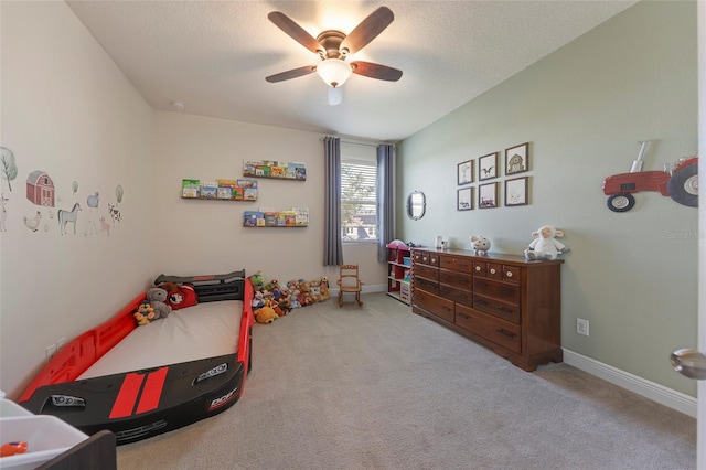 carpeted bedroom featuring ceiling fan and a textured ceiling