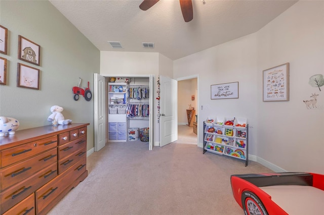 carpeted bedroom featuring a textured ceiling, a closet, and ceiling fan