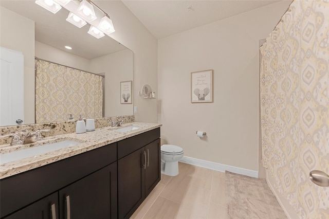 bathroom with tile patterned flooring, vanity, and toilet