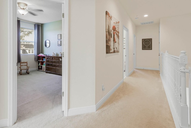 hallway with light colored carpet