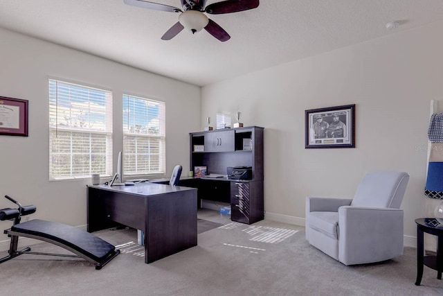 carpeted home office with ceiling fan and a textured ceiling