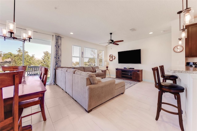 living room with ceiling fan with notable chandelier