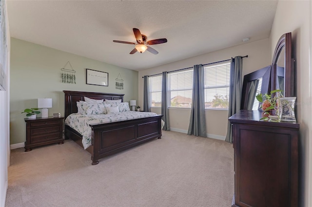 carpeted bedroom with ceiling fan and a textured ceiling