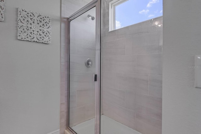 bathroom with a shower with door