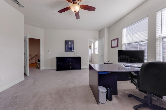 office area with light carpet, a wealth of natural light, and ceiling fan