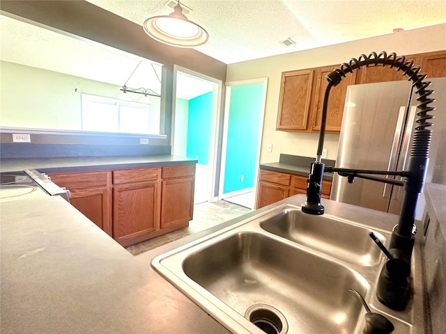 kitchen featuring sink, stove, and a textured ceiling