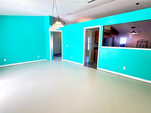 spare room featuring concrete flooring and a textured ceiling