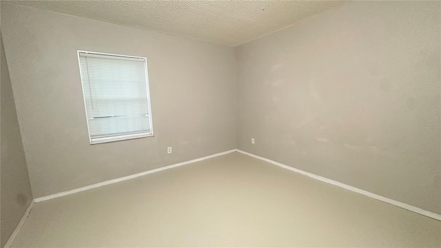 spare room with concrete floors and a textured ceiling