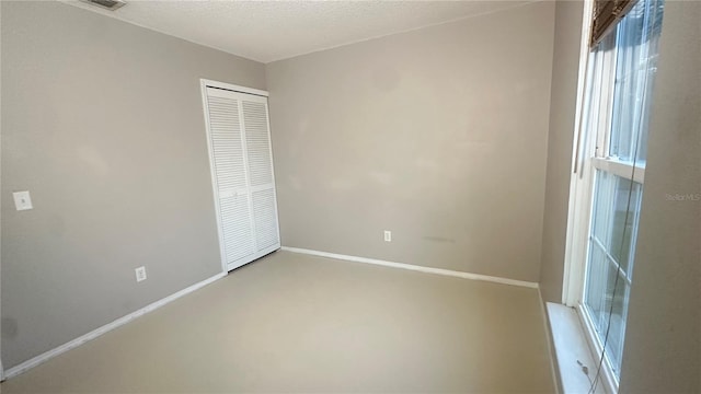 unfurnished bedroom with a textured ceiling and a closet