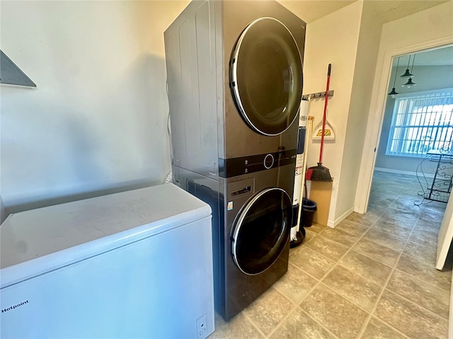 clothes washing area featuring stacked washer / dryer