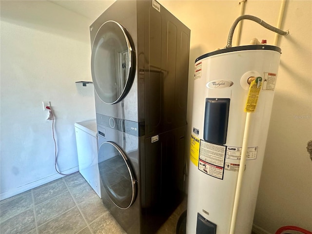 clothes washing area with water heater and stacked washer and dryer