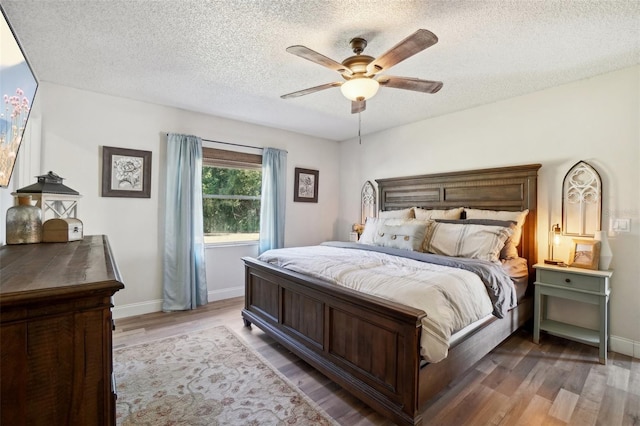 bedroom featuring ceiling fan, dark wood-type flooring, and a textured ceiling