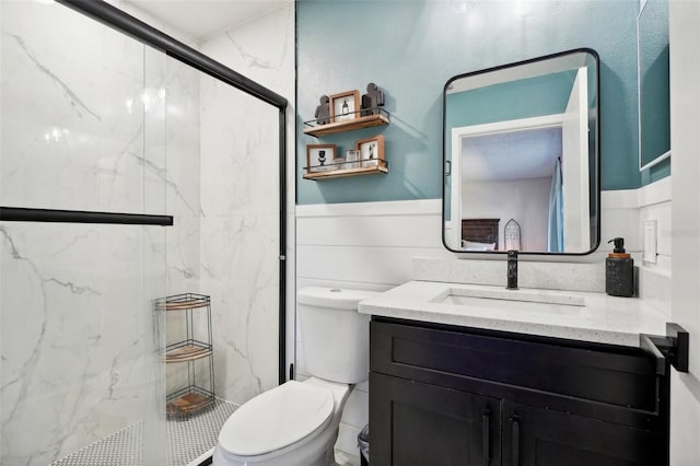 bathroom featuring vanity, a shower with shower door, and toilet