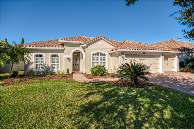 mediterranean / spanish home featuring a front yard and a garage