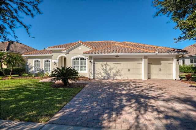 mediterranean / spanish home with a front yard and a garage