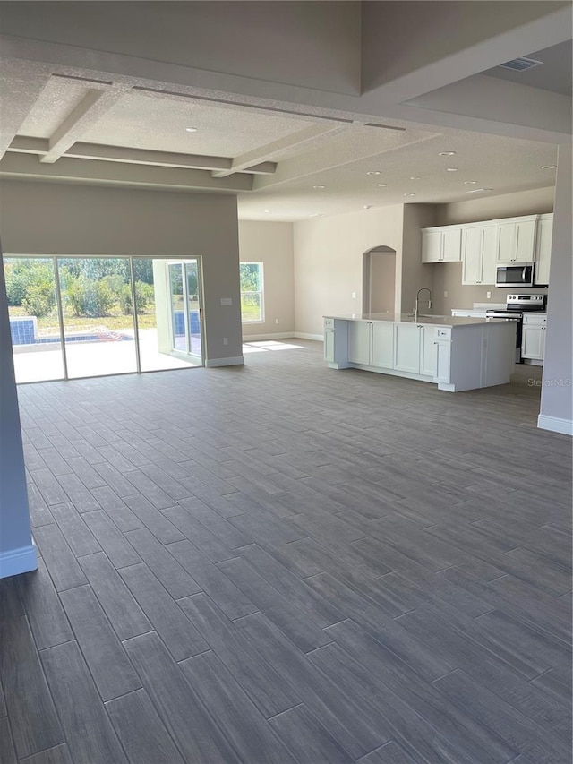 unfurnished living room with beamed ceiling