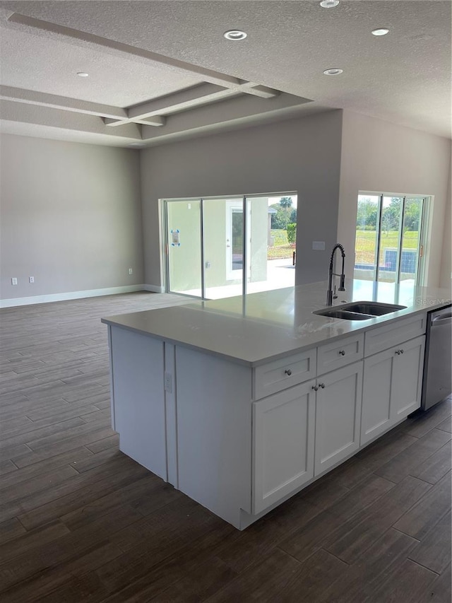 kitchen with sink, a textured ceiling, dark hardwood / wood-style flooring, dishwasher, and white cabinets