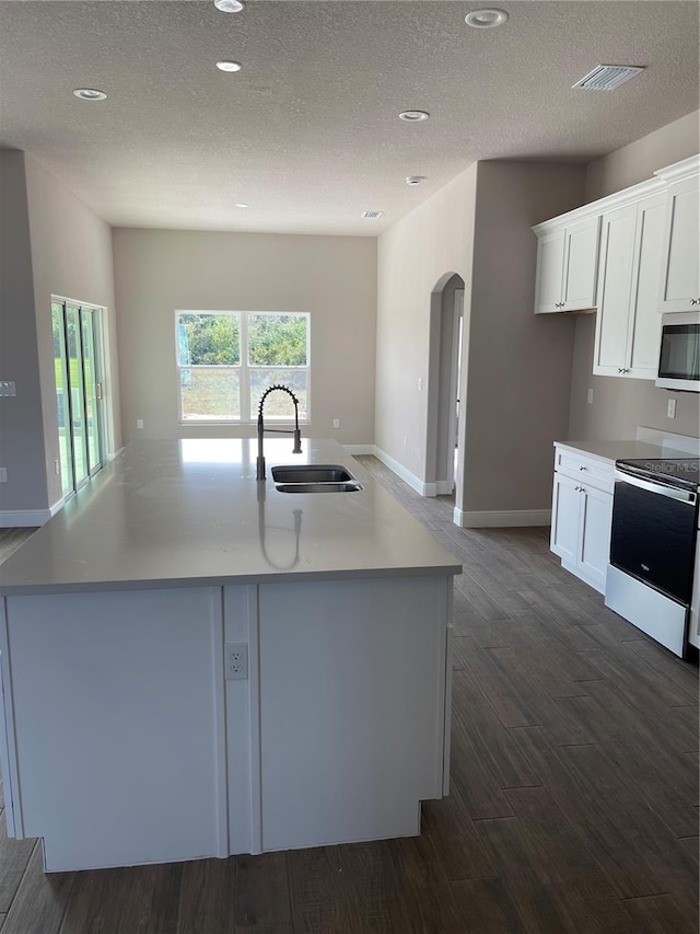 kitchen featuring stainless steel appliances, white cabinetry, a kitchen island with sink, and sink