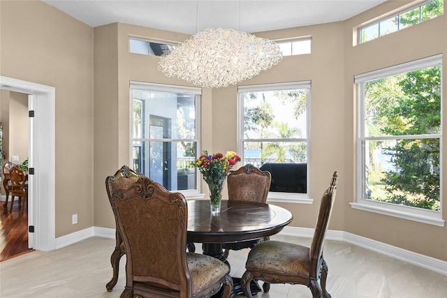 dining area with light hardwood / wood-style flooring, an inviting chandelier, and plenty of natural light